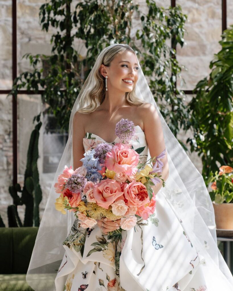 Bride holding a colourful bouquet in a greenhouse