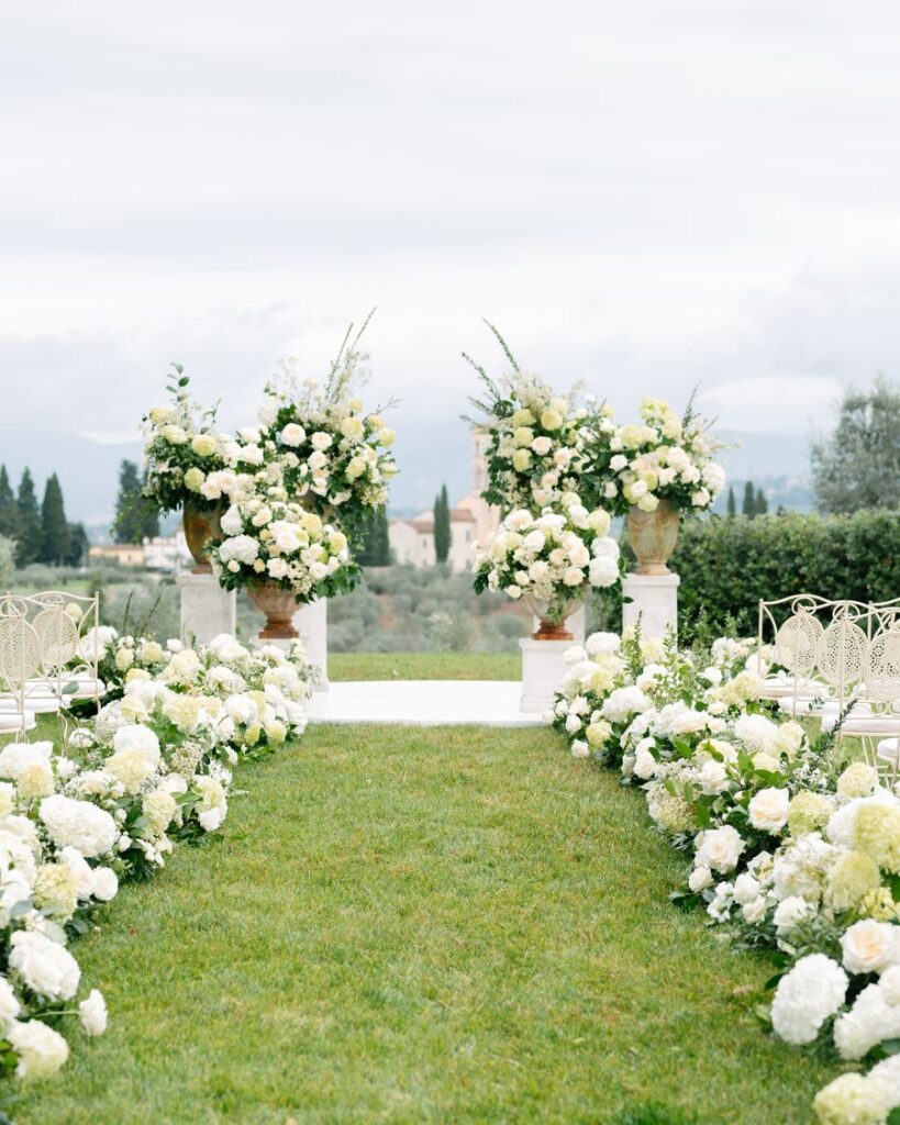 Wedding ceremony aisle lined with white hydrangeas