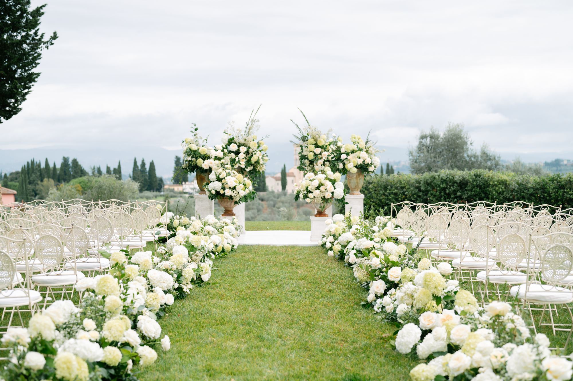 Bride and groom walking through the aisle among guests and white flowers